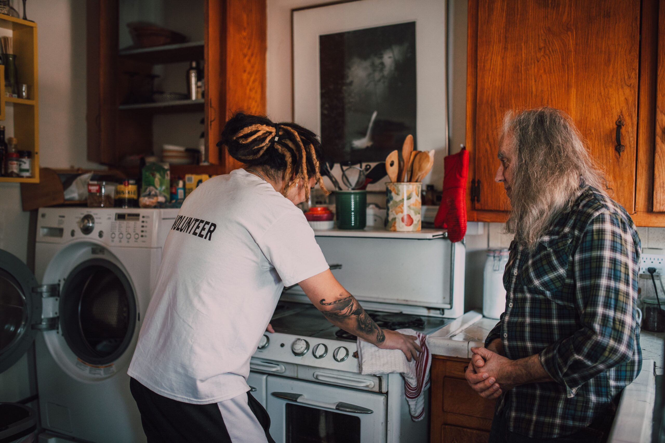 Caregiver helping an older adult with household task.